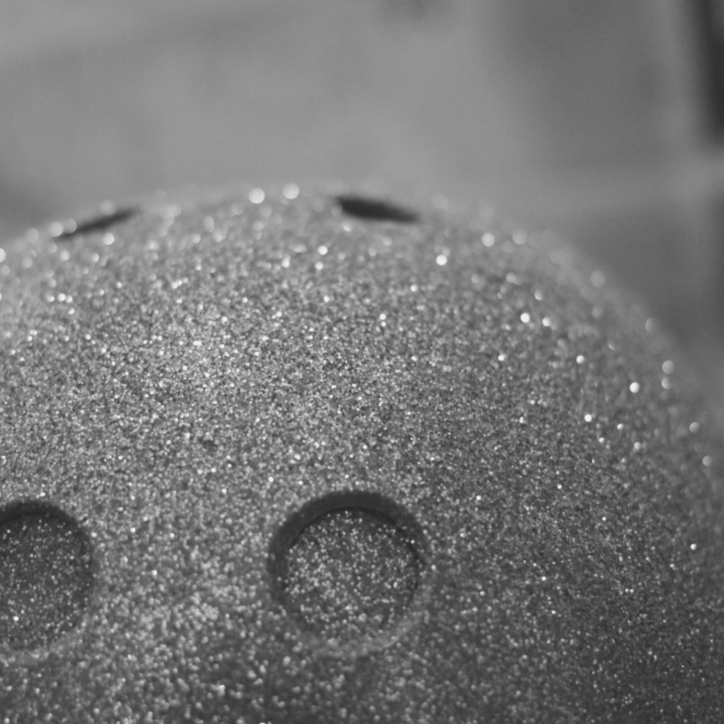 A close up photo of the front of a roller skating helmet that has been painted and covered in glitter.